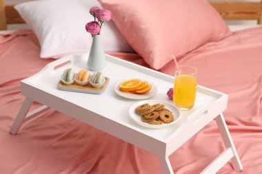 Nefis bir kahvaltı tepsisi ve kapalı bir odada çiçekler.