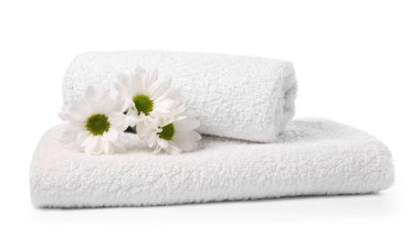 Yumuşak havlular ve beyaza izole edilmiş kasımpatı çiçekleri.