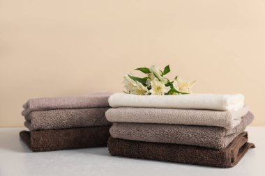 Beyaz masa üzerinde bej arka planda yumuşak havlu ve zambak yığını