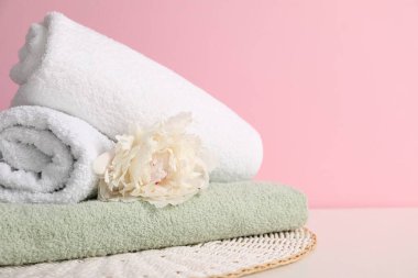 Yumuşak havlu yığını ve şakayık çiçeği pembe arka plana karşı, yakın plan. Metin için boşluk