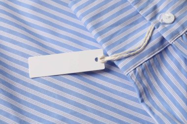Çizgili gömlekte karton etiket, üst görünümde.