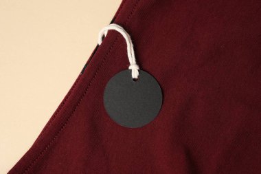 Bej arkaplanda etiketli kırmızı giysi, üst görünüm