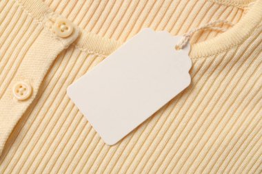 Karton etiketli bej giysi, üst görünüm
