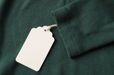 Yeşil kumaş üzerinde karton etiket, üst görünüm