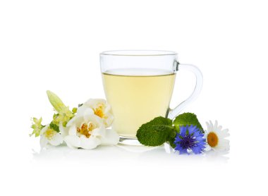 Cam bardakta aromatik bitki çayı, beyaz bardakta izole edilmiş nane ve çiçekler.