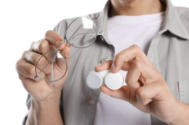 Beyaz arka planda gözlüklü ve kontak lensli adam, yakın plan.