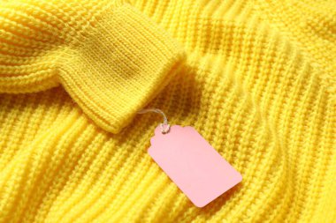 Sarı örülmüş süveterin üzerindeki karton etiket.