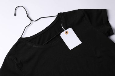 Beyaz arkaplanda etiketli tişört, üst görünüm