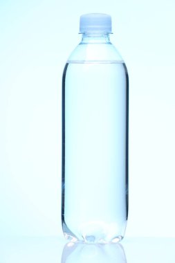 Beyaz zemin üzerinde temiz su olan plastik şişe.