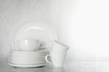 Beyaz mermer masa üzerinde farklı temiz bulaşık takımı, metin için yer