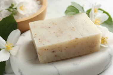 Sabun barı, deniz tuzu ve yasemin çiçekleri masada, yakın plan.