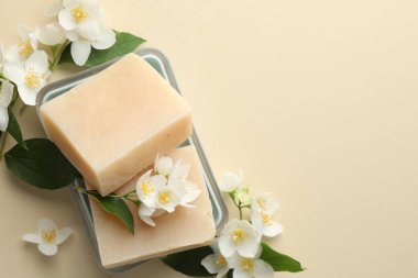 Bej arka planda sabun çubukları ve yasemin çiçekleri. Metin için boşluk