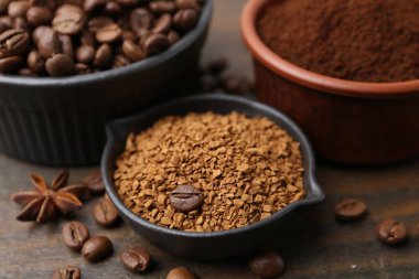 Farklı tipte kahve ve fasulyeler ahşap masada, yakın plan.