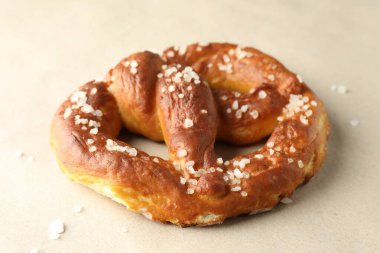 Bej arkaplanda tuz bulunan lezzetli krakerler, yakın plan.