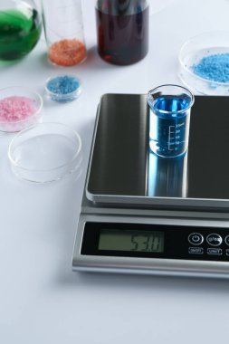 Beyaz arka planda deney tüpü ve diğer laboratuvar ekipmanlarıyla ölçeklendir