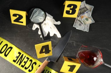 Adli tıp uzmanı. Sarı olay yeri bandı, siyah masanın üstünde işaretler ve kanıtlar var.