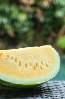 Dışarıdaki hasır masada leziz bir karpuz dilimi, yakın plan.