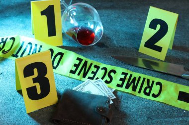 Adli tıp uzmanı. Sarı olay yeri bandı, işaretler, para dolu cüzdan, bıçak ve şarap kadehi gri masada, yakın plan.