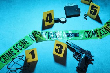 Adli tıp uzmanlığı. Delil, işaretler ve mavi arka planda polis bandı olan suç mahalli. Renkli tonlama efekti