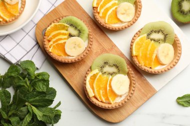 Meyveli tart ve nane şekerli beyaz masa, düz. Tatlı nefis.