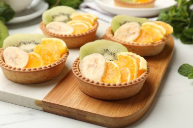 Meyveli turta ve nane şekerli beyaz masa, yakın plan. Tatlı nefis.