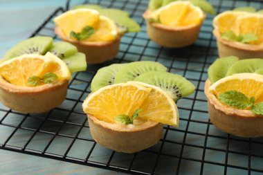 Meyveli tart ve açık mavi ahşap masada nane şekeri, yakın plan. Tatlı nefis.