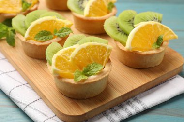 Meyveli tart ve açık mavi ahşap masada nane şekeri, yakın plan. Tatlı nefis.