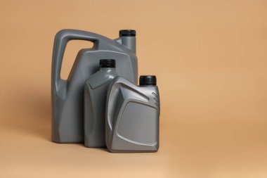Bej arka planda plastik kutularda motor yağı, metin için boşluk