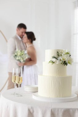 Mutlu evli çift içeride, düğün pastasına ve masadaki şampanya bardaklarına odaklan.