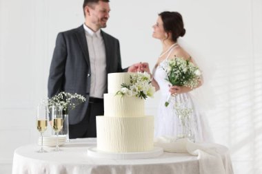 Mutlu evli çift içeride, masadaki düğün pastasına odaklan.