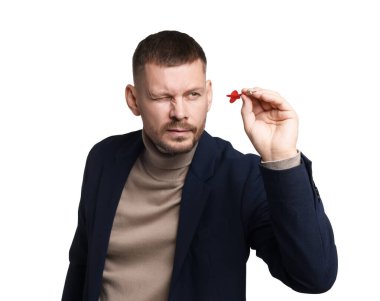 Hedef alınıyor. Beyaz arkaplanı hedefleyen dartlı bir adam.