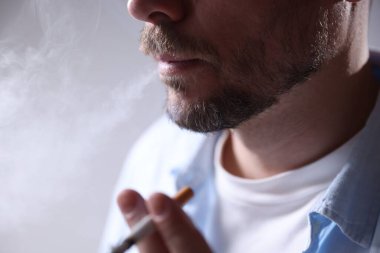 Arka planda sigara içen adam, yakın plan.