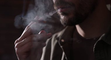 Arka planda sigara içen adam, yakın plan.