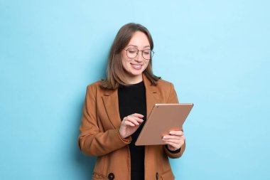 Açık mavi arka planda modern tabletli kadın