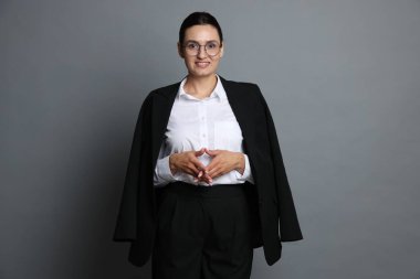 Gri arka planda kendine güvenen iş kadını