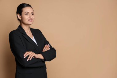 Bej arka planda takım elbiseli kendine güvenen bir iş kadını. Metin için boşluk