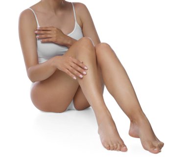 Beyaz arka plandaki epilasyondan sonra güzel pürüzsüz bacakları olan kadın, yakın plan.