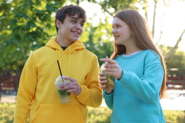 Parkta içki içen genç bir kız ve oğlan.