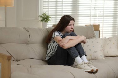 Evdeki kanepede depresif genç kız.