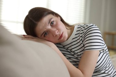 Evdeki kanepede depresif genç kız.