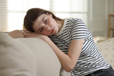 Evdeki kanepede depresif genç kız.