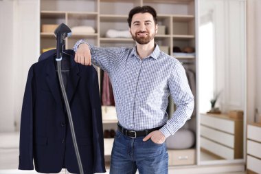 Kapalı mekanda vapur ve ceket giyen adam.