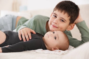 Evdeki kanepede oturan sevimli küçük kardeşler.