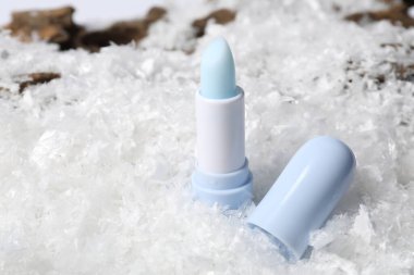 Yapay karda nemlendirici dudak kremi, yakın plan. Kış bakımı