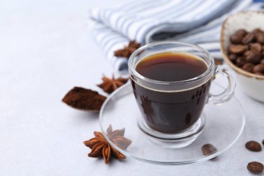 Bir fincan aromatik kahve, fasulye ve yıldız anason beyaz masada, yakın plan. Metin için boşluk