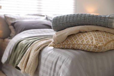 Odasında yumuşak çarşaflar ve battaniyeler olan rahat bir yatak, yakın plan. Ev tekstili