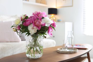 Bir buket güzel şakayık ve sehpanın üzerinde su. İç tasarım