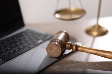 Yargıç. Dizüstü bilgisayar, tokmak ve teraziler ofisteki ahşap masada, yakın plan.