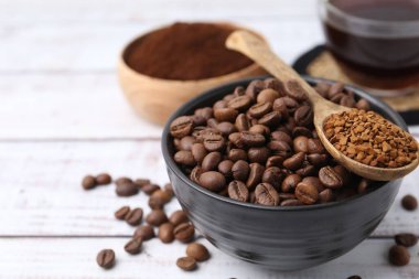 Kavrulmuş fasulye ve granüle edilmiş kahve beyaz ahşap masada, yakın plan.