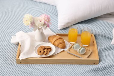 Nefis bir kahvaltı tepsisi ve çiçeklerle kapalı bir yerde, yakın plan.